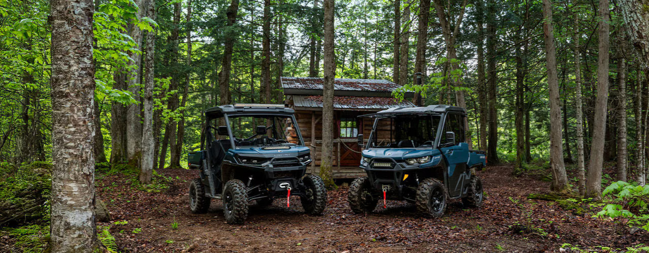 two utvs parked in the middle of a forest